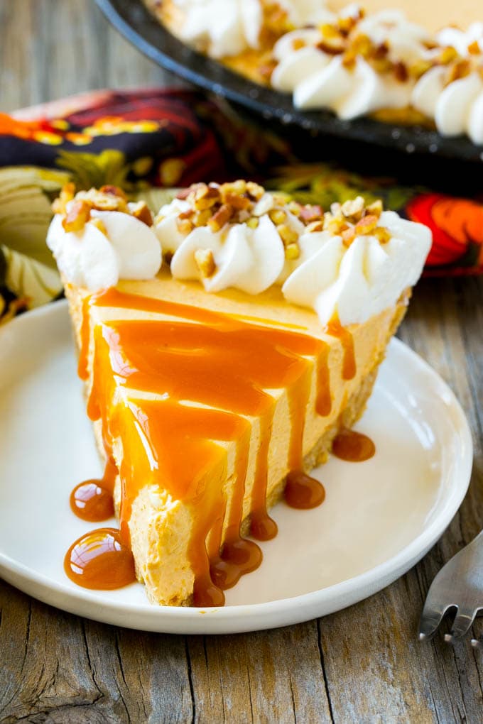 No Bake Pumpkin Cheesecake Recipe | Pumpkin Cheesecake | No Bake Cheesecake | Thanksgiving Dessert | Pumpkin Dessert #nobake #cheesecake #pumpkin #pumpkinpie #pumpkincheesecake #nobakecheesecake #dessert #edsug A slice of cheesecake topped with a caramel drizzle.
