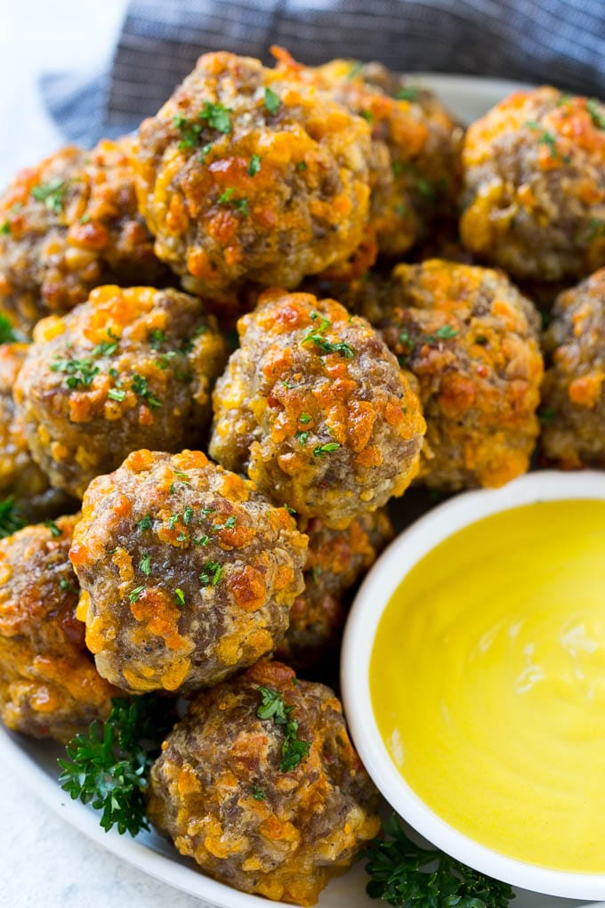 Sausage Cheese Balls Recipe | Sausage Balls Recipe | Bisquick Sausage Balls #sausage #sausageballs #balls #appetizer #cheeseballs #edsug A platter of sausage cheese balls with honey mustard sauce for dipping.