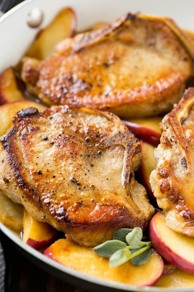 Apple Pork Chops Recipe | Pork Chops with Apples | Cider Pork Chops | Bone In Pork Chops Recipe #pork #porkchops #fall #apple #dinner #edsug Seared pork in a pan in a sweet and savory sauce with fresh herbs.