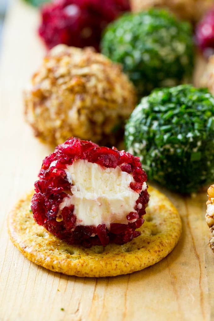 Cheese Ball Bites Recipe | Holiday Cheese Ball Recipe | Pecan Cheese Ball | Cranberry Cheese Ball | Mini Cheese Balls #cheeseball #cheese #appetizer #edsug A cranberry crusted ball of cheese on a cracker.