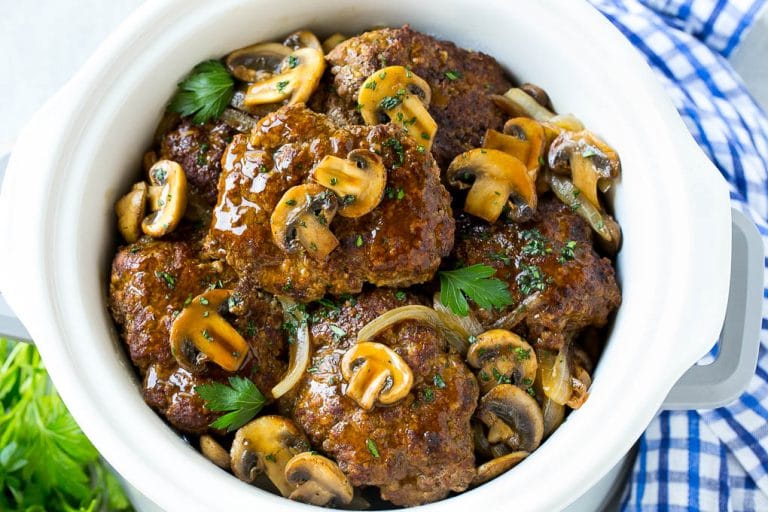 Slow Cooker Salisbury Steak Recipe | Homemade Salisbury Steak | Salisbury Steak from Scratch #steak #beef #salisbury #salisburysteak #slowcooker #crockpot #dinner #edsug A crock pot full of slow cooker salisbury steak.