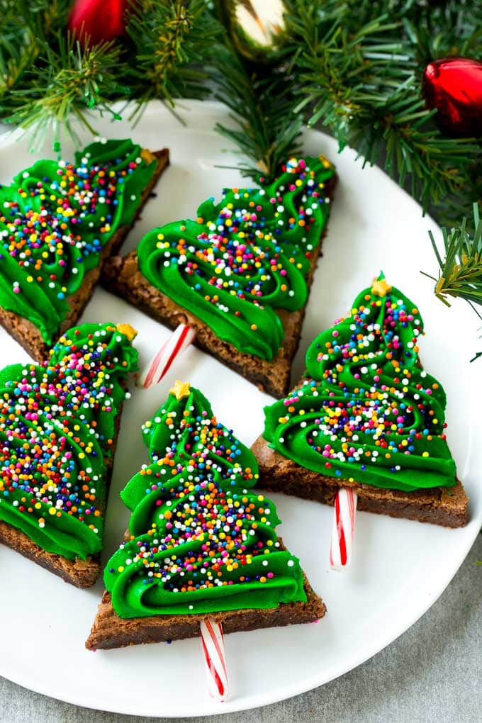 title="Christmas Tree Brownies | Christmas Brownies | Holiday Brownies | Christmas Tree Dessert #brownies #dessert #christmas #holiday #dessert #edsug" Christmas Brownies topped with frosting and rainbow sprinkles on a plate.