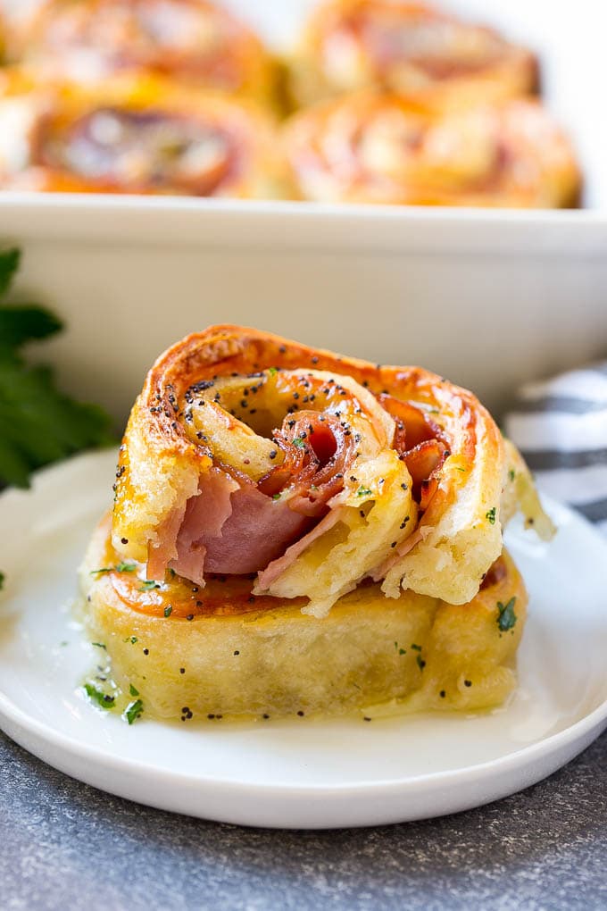 Ham and Cheese Pinwheels Recipe | Ham and Cheese Roll Ups | Ham and Cheese Rolls | Ham and Cheese Bread Rolls #ham #cheese #appetizer #pinwheels #edsug Ham and cheese pinwheels stacked on a serving plate.