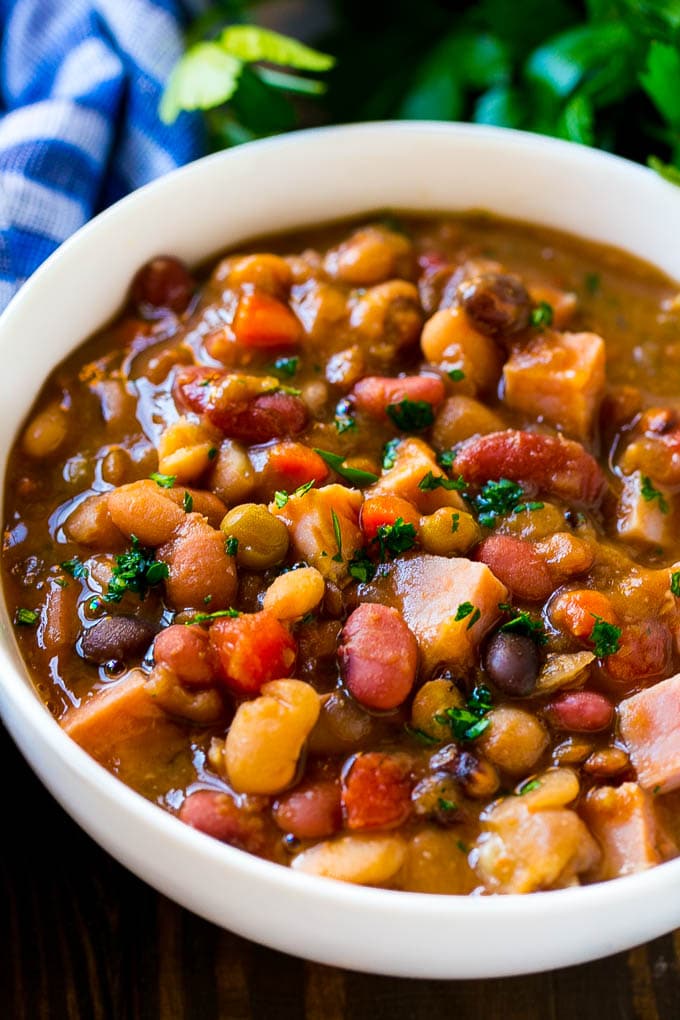 Slow Cooker Ham Bone Soup | Ham and Bean Soup | Ham Bone and Bean Soup | Ham Soup | Leftover Ham Recipe #ham #hamsoup #leftoverham #soup #slowcooker #crockpot #edsug A bowl of ham bone soup with beans and vegetables.