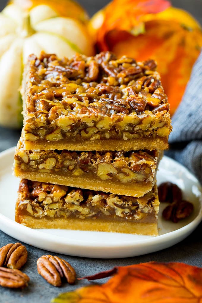 Pecan Pie Bars Recipe #pecans #pie #fall #pecanpie #dessert #thanksgiving #edsug A stack of pecan pie bars on a plate.