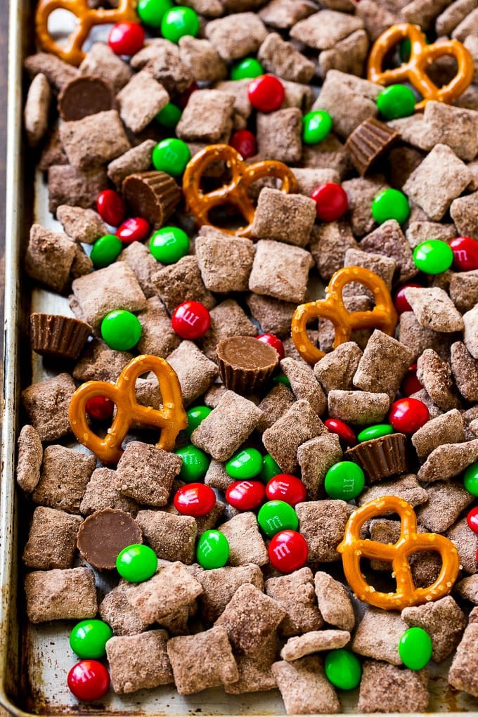 Reindeer Chow | Christmas Chex Mix | Christmas Muddy Buddies | Holiday Chex Mix #chex #chexmix #christmas #holiday #muddybuddies #reindeerchow #snack #edsug A sheet pan of Christmas muddy buddies mixed with candy and peanut butter cups.