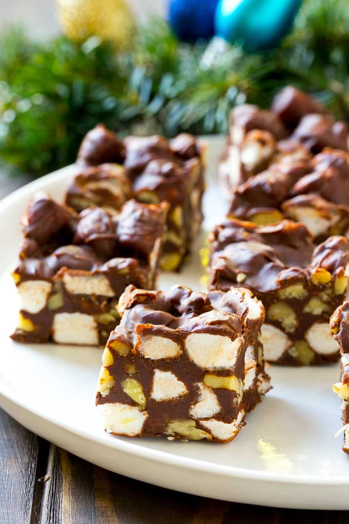 Rocky Road Fudge | Chocolate Marshmallow Fudge | Chocolate Nut Fudge | Microwave Fudge #fudge #chocolatefudge #nobake #chocolate #dessert #rockyroad #edsug Squares of rocky road fudge on a serving plate.