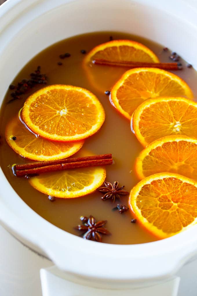 Slow Cooker Apple Cider | Mulled Apple Cider | Crockpot Apple Cider #cider #apple #applecider #drink #crockpot #slowcooker #edsug Crock pot spiced drink with orange slices and aromatic spices.