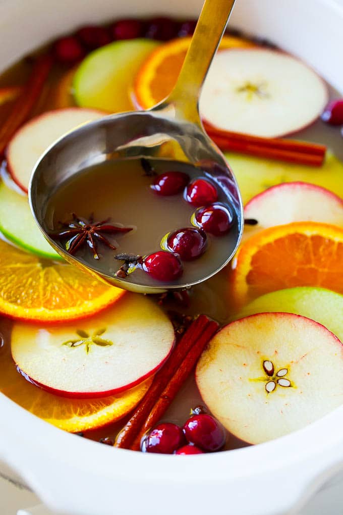 Slow Cooker Apple Cider | Mulled Apple Cider | Crockpot Apple Cider #cider #apple #applecider #drink #crockpot #slowcooker #edsug A ladle scooping out some warm mulled drink.