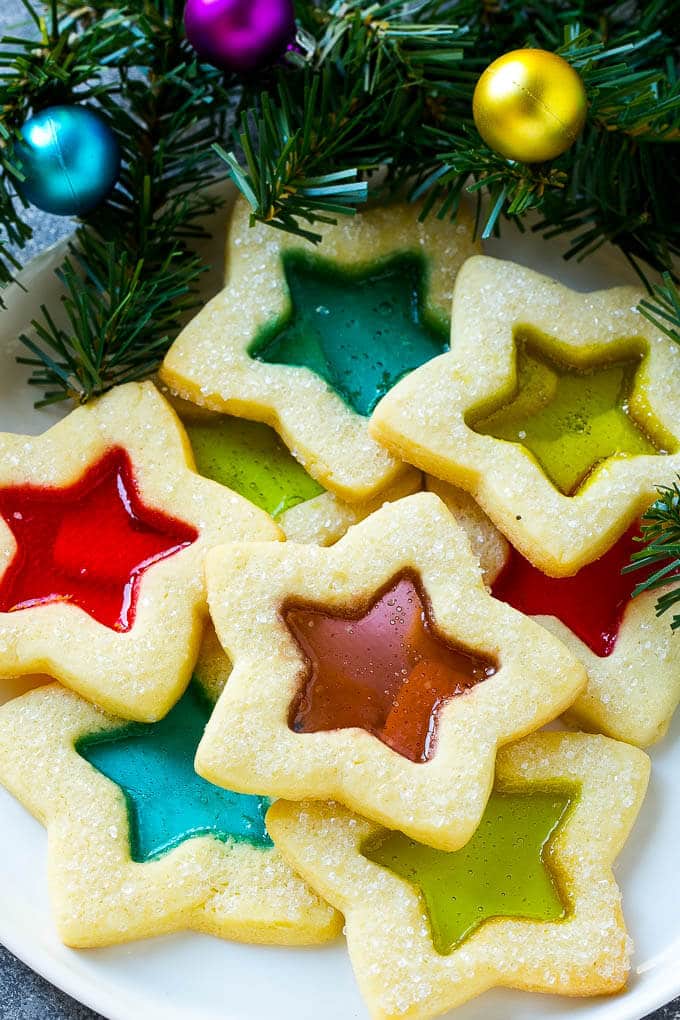 Stained Glass Cookies | Stained Glass Window Cookies | Christmas Cookies | Sugar Cookies | Holiday Cookies #cookies #stainedglasscookies #sugarcookies #christmascookies #christmas #holiday #dessert #edsug A plate of star shaped stained glass cookies with colorful centers.