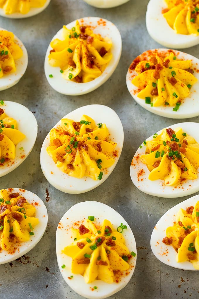 Bacon Deviled Eggs | Deviled Eggs Recipe #eggs #keto #lowcarb #bacon #appetizer #edsug Bacon deviled eggs topped with chives and paprika on a sheet pan.