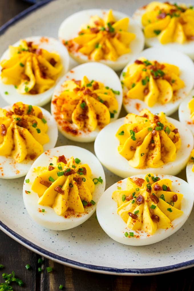 Bacon Deviled Eggs | Deviled Eggs Recipe #eggs #keto #lowcarb #bacon #appetizer #edsug A plate of bacon deviled eggs garnished with sliced chives and smoked paprika.