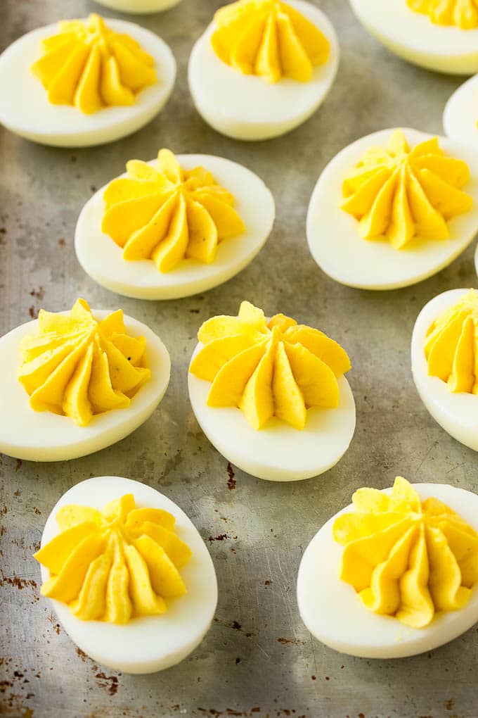 Bacon Deviled Eggs | Deviled Eggs Recipe #eggs #keto #lowcarb #bacon #appetizer #edsug Deviled eggs with a decoratively piped filling on a sheet pan.