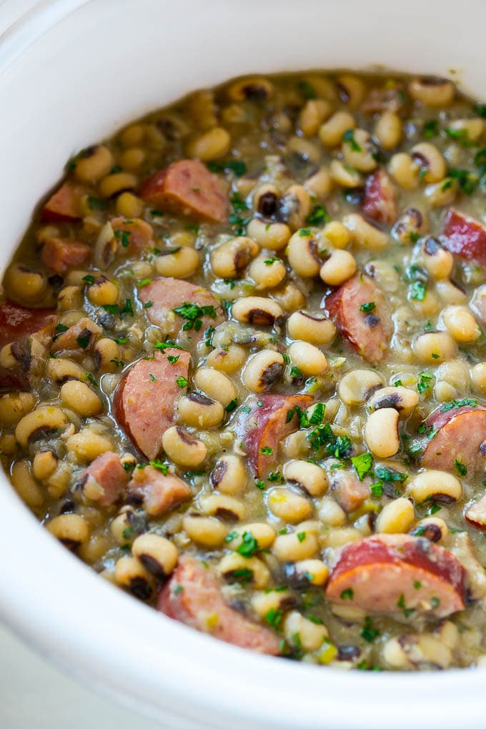 Slow Cooker Black Eyed Peas Recipe | Crock Pot Black Eyed Peas | Southern Black Eyed Peas | Black Eyed Peas with Ham | Black Eyed Peas with Sausage #blackeyedpeas #slowcooker #crockpot #sausage #newyears #dinner #edsug These crock pot black eyed peas with sausage and ham are the perfect meal for new years.