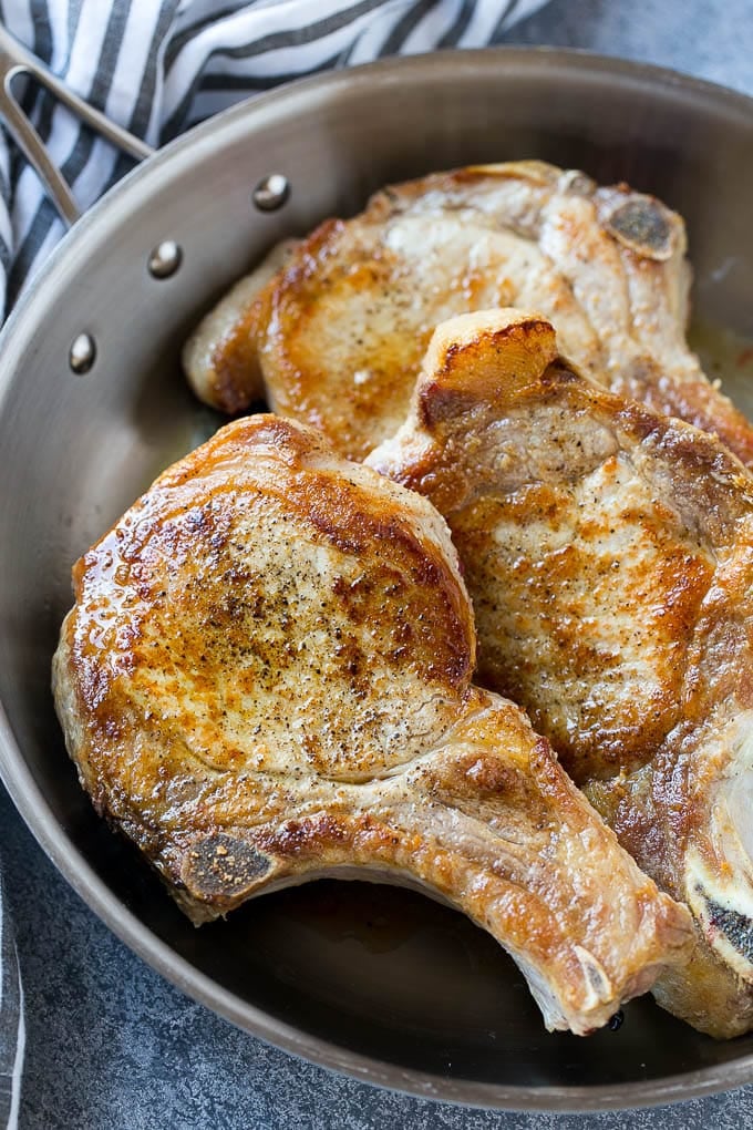 Brown Sugar Pork Chops Recipe | Bone In Pork Chops Recipe | Garlic Butter Pork Chops | Skillet Pork Chops #pork #porkchops #garlic #dinner #glutenfree #edsug Browned bone in pork chops in a frying pan.