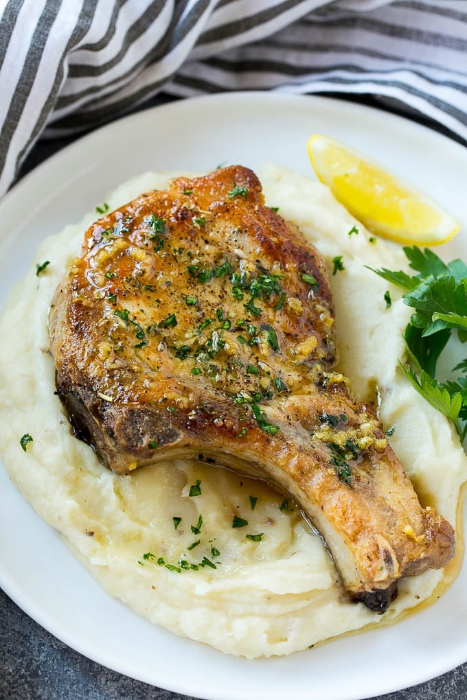 Brown Sugar Pork Chops Recipe | Bone In Pork Chops Recipe | Garlic Butter Pork Chops | Skillet Pork Chops #pork #porkchops #garlic #dinner #glutenfree #edsug Brown sugar pork chops on a bed of mashed potatoes.