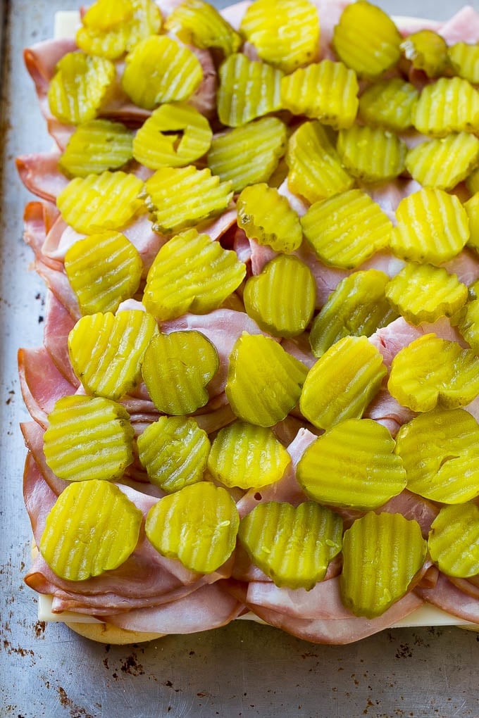 Cuban Sliders Recipe | Cuban Sandwich Recipe | Slider Sandwiches | Ham and Cheese Sliders #sliders #sandwiches #ham #cheese #appetizer #edsug Bread layered with cheese, ham and pickles.