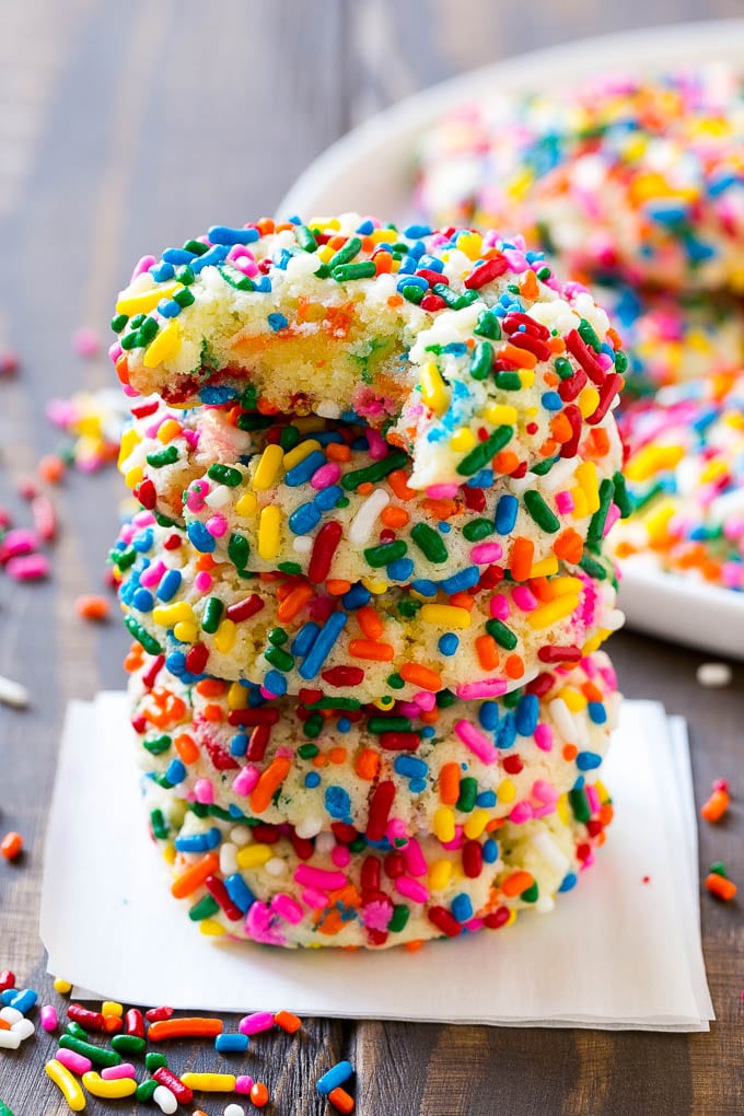 Funfetti Cookies Recipe | Funfetti Cake Mix Cookies | Sprinkle Cookies | Cake Mix Cookies #cookies #funfetti #sprinkles #dessert #edsug A stack of funfetti cookies with a bite taken out of one.