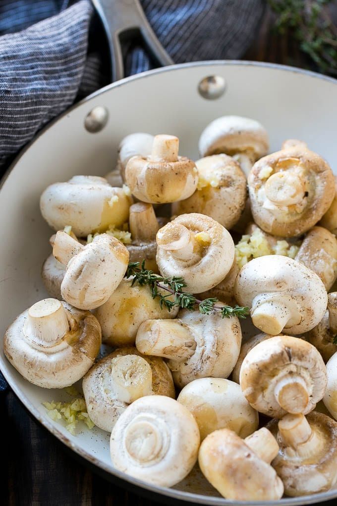 Garlic Mushrooms Recipe | Steakhouse Mushrooms | Sauteed Mushrooms | Garlic Butter Mushrooms | Mushroom Side Dish #mushrooms #butter #keto #lowcarb #dinner #sidedish #edsug Uncooked buttons with herbs and butter in a frying pan.