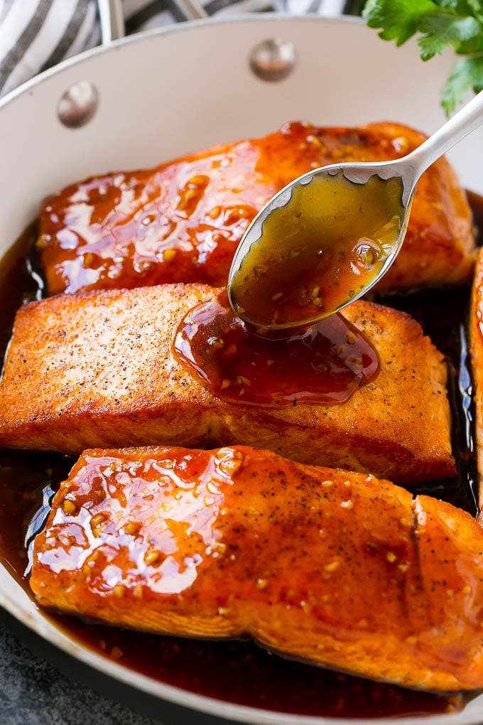 Honey Garlic Salmon Recipe | Asian Salmon Recipe | Healthy Salmon Recipe #salmon #fish #seafood #healthy #dinner #edsug A spoon pouring sauce on top of salmon fillets.