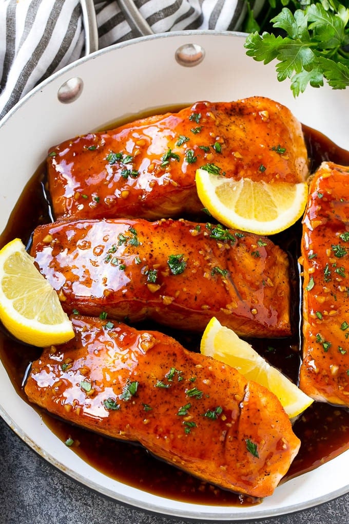Honey Garlic Salmon Recipe | Asian Salmon Recipe | Healthy Salmon Recipe #salmon #fish #seafood #healthy #dinner #edsug A pan of honey garlic salmon topped with a savory sauce and garnished with parsley and lemon.