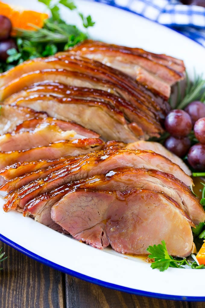 Coca Cola Ham | Coke Glazed Ham | Easter Ham | Christmas Ham | Holiday Ham Recipe #ham #easter #christmas #dinner #edsug A platter of sliced coca cola ham with herbs.