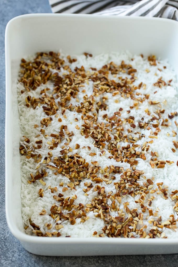 Earthquake Cake Recipe | Chocolate Cake Recipe | Chocolate Coconut Cake | Coconut Pecan Cake #cake #chocolate #coconut #pecans #dessert #chocolatecake #edsug Coconut and pecans layered into a cake pan.