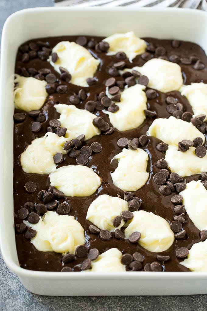 Earthquake Cake Recipe | Chocolate Cake Recipe | Chocolate Coconut Cake | Coconut Pecan Cake #cake #chocolate #coconut #pecans #dessert #chocolatecake #edsug Chocolate cake batter topped with dollops of sweetened cream cheese and chocolate chips.