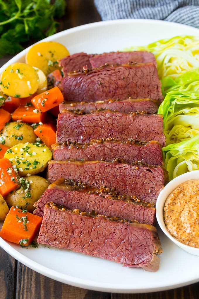 Slow Cooker Corned Beef Recipe | Crock Pot Corned Beef | Corned Beef and Cabbage #beef #cornedbeef #cabbage #potatoes #carrots #stpatricksday #irish #edsug A platter of slow cooker corned beef, cabbage wedges, potatoes and carrots.