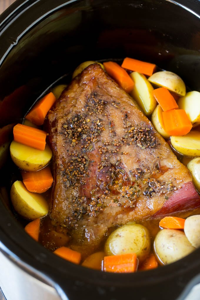 Slow Cooker Corned Beef Recipe | Crock Pot Corned Beef | Corned Beef and Cabbage #beef #cornedbeef #cabbage #potatoes #carrots #stpatricksday #irish #edsug A seasoned brisket with potatoes and carrots in a slow cooker.