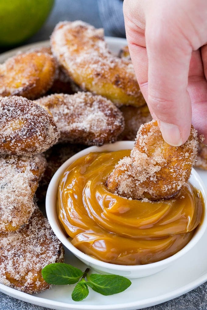 Apple Fries Recipe | Fried Apples Recipe | Cinnamon Sugar Apples | Apple Dessert Recipe #apples #dessert #edsug #fall An apple fry being dipped into caramel sauce.