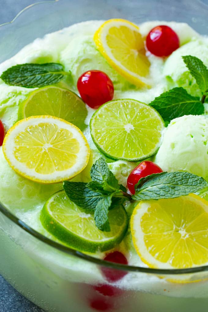 Lime Sherbet Punch | Party Punch Recipe | Sherbet Punch Recipe | Limeade Recipe #sherbet #punch #lime #drink #edsug A close up of a bowl of sherbet punch garnished with citrus and mint.
