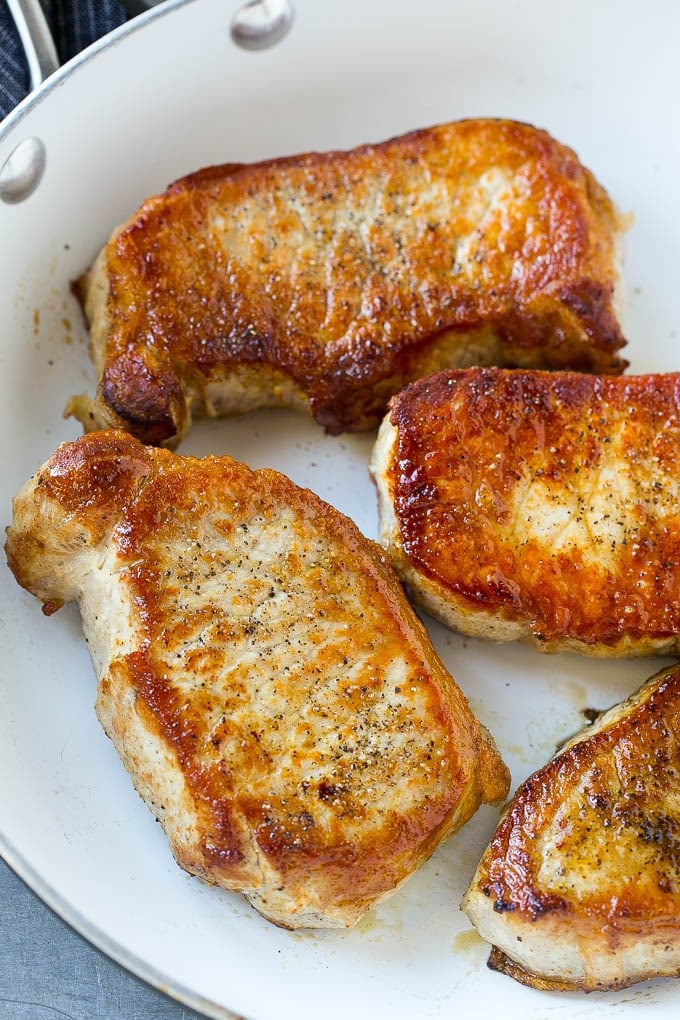 A skillet of seared boneless pork chops.
