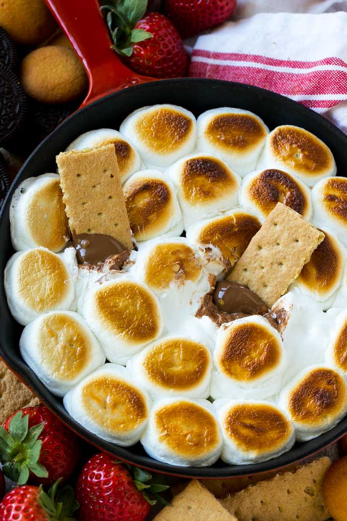 S'mores Dip Recipe | S'mores Skillet | Baked S'mores #smores #dip #chocolate #marshmallow #dessert #edsug A skillet of s'mores dip with melted milk chocolate topped with toasted marshmallows.