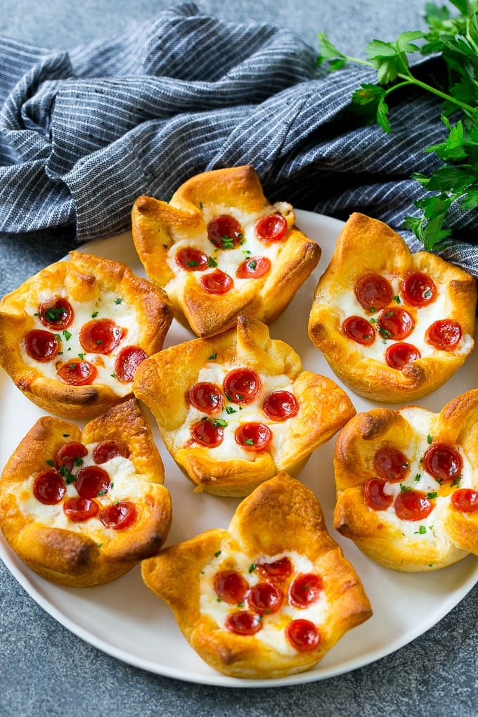 Pizza Muffins Recipe | Pizza Bites | Pizza Cups | Pizza Appetizer #pizza #appetizer #edsug Pizza muffins on a serving plate garnished with parsley.