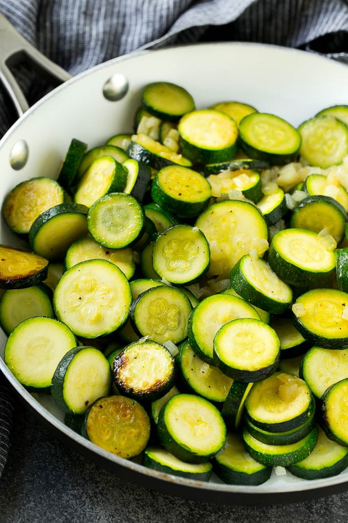Zucchini Gratin Recipe | Cheesy Zucchini | Baked Zucchini | Easy Zucchini Recipe #zucchini #casserole #cheese #dinner #sidedish #edsug Sauteed zucchini and onions in a skillet.
