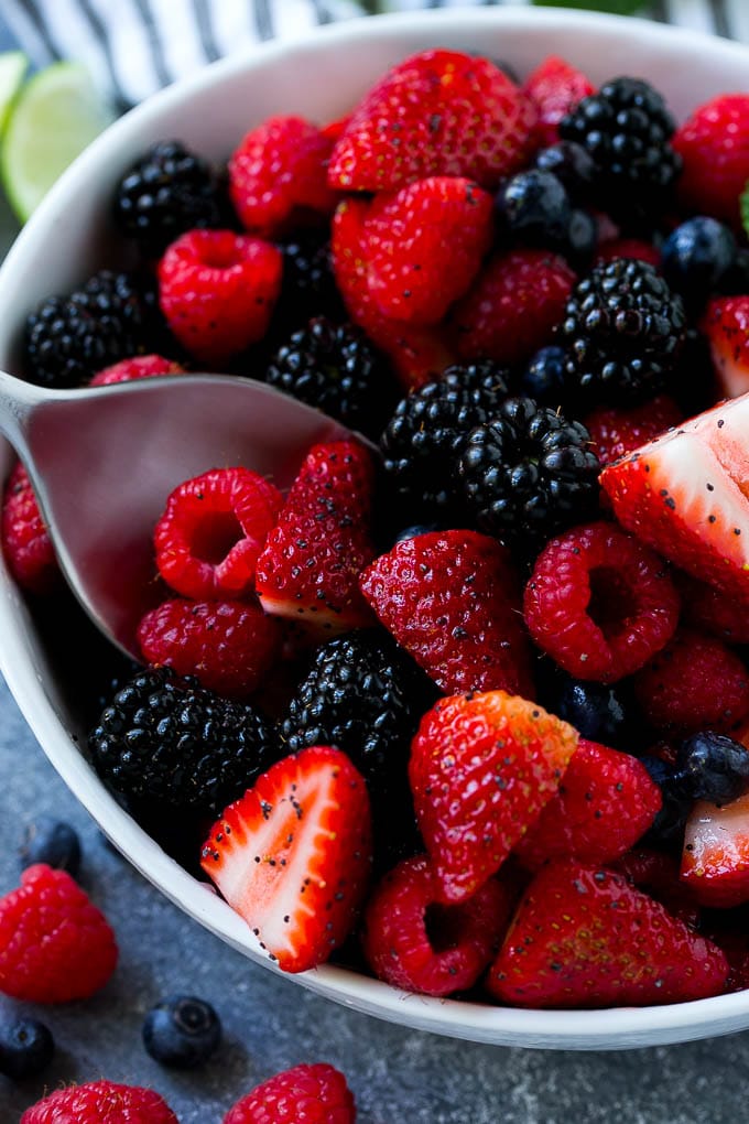 Berry Fruit Salad Recipe | Berry Salad | Summer Berry Salad | Fruit Salad Recipe #berries #fruitsalad #edsug A bowl of berry fruit salad with a serving spoon in it.