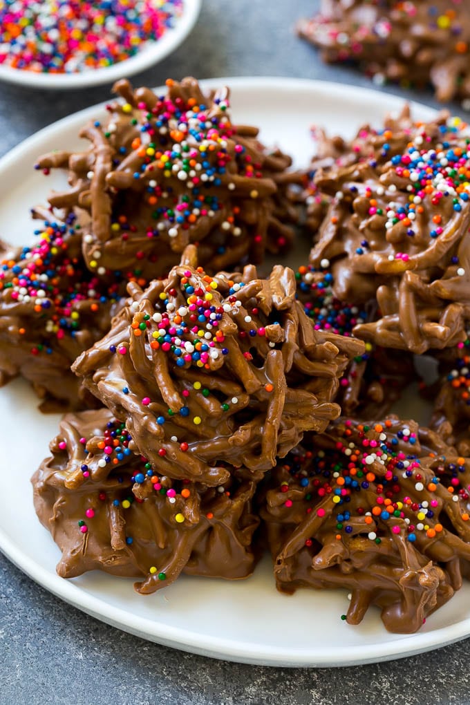 Haystack Cookies Recipe | No Bake Cookies | Chow Mein Noodle Cookies #nobakecookies #cookies #recipe #chocolate #edsug A plate of haystack cookies topped with rainbow sprinkles.