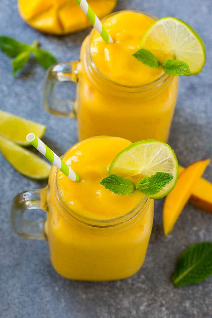 Mango Smoothie Recipe | Mango Recipe | Healthy Smoothie #mango #smoothie #drink #edsug Two jars full of mango smoothie, garnished with lime slices and fresh mint.