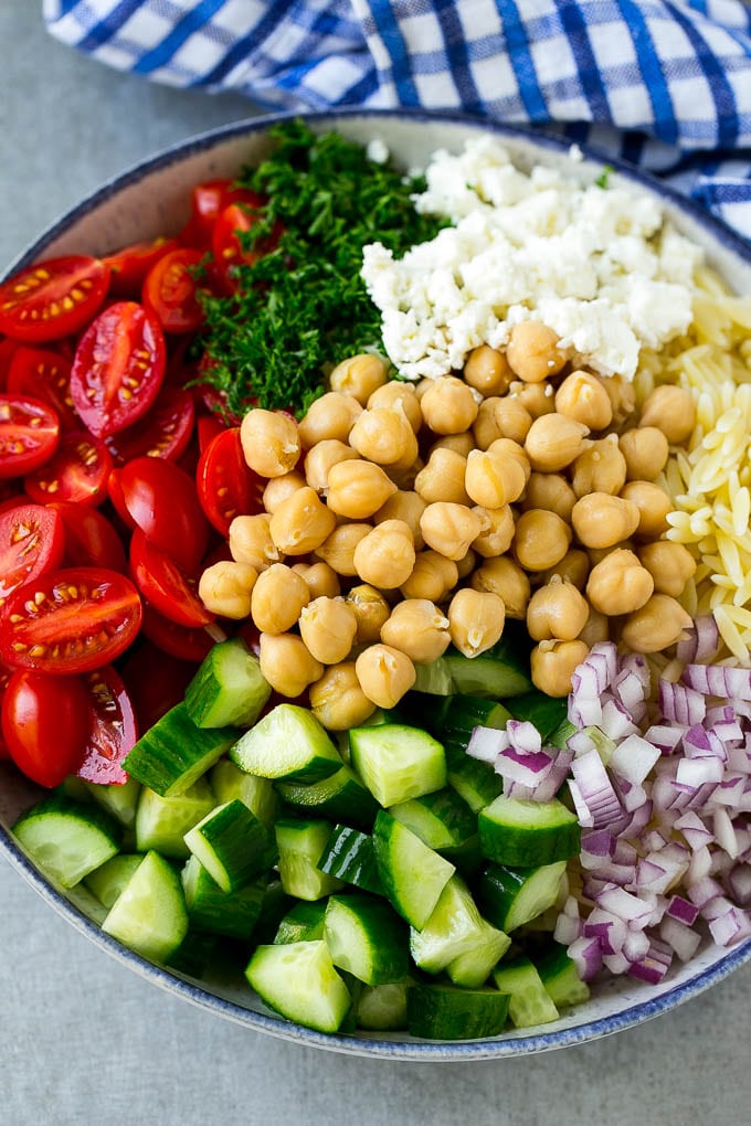 Orzo Salad Recipe | Orzo Pasta Salad | Greek Orzo Salad | Mediterranean Orzo Salad #pastasalad #orzo #greekfood #salad #edsug A bowl of orzo pasta, cucumbers, cherry tomatoes, feta cheese, red onions, herbs and chickpeas.