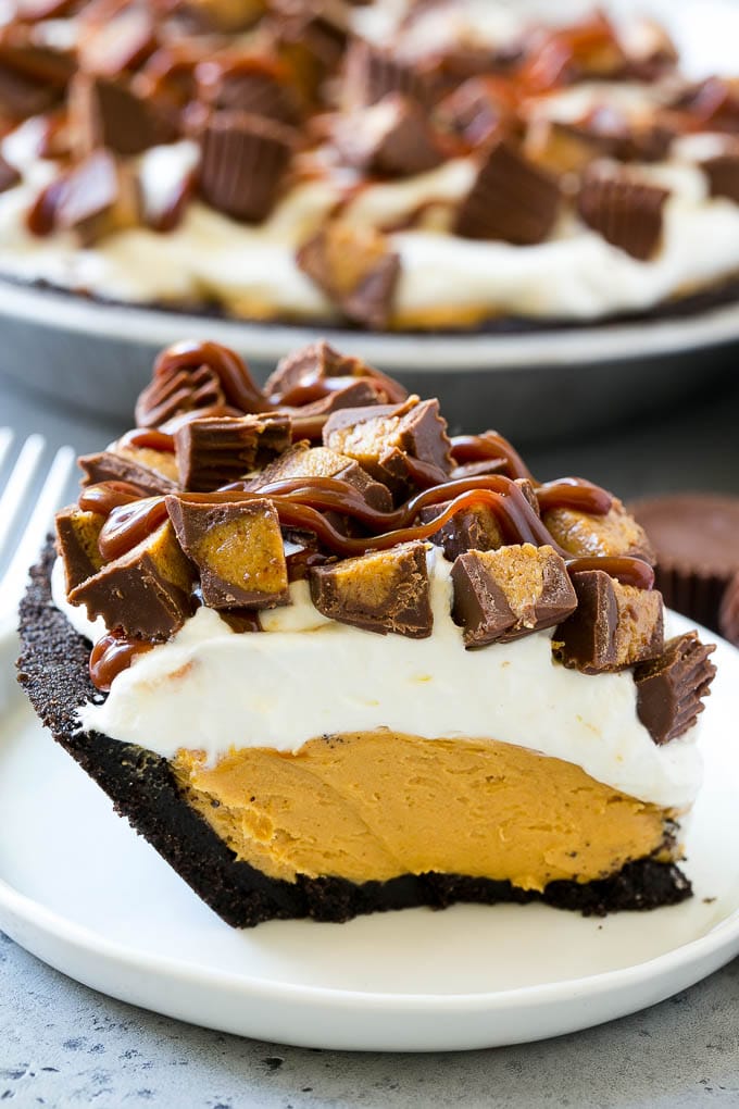 Chocolate Peanut Butter Pie Recipe | Peanut Butter Cup Pie | Peanut Butter Pie | No Bake Pie #chocolate #peanutbutter #pie #nobake #dessert #edsug A slice of chocolate peanut butter pie topped with whipped cream, chocolate sauce and peanut butter cups.