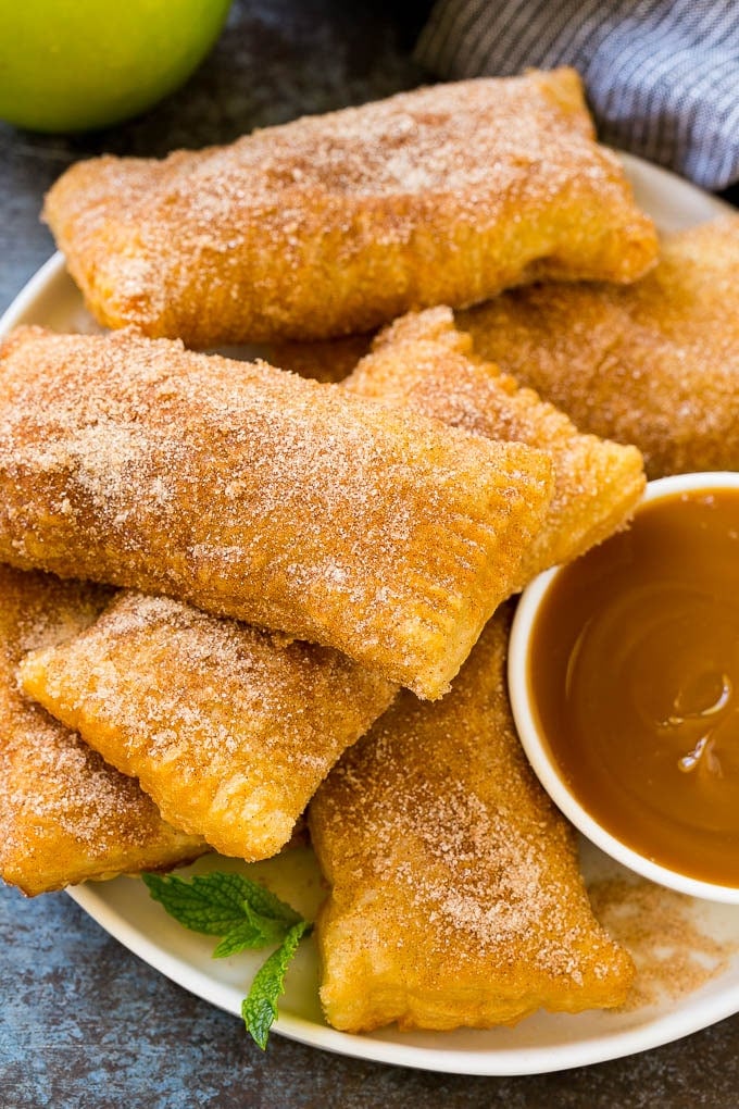 Fried Apple Pies Recipe | McDonald's Copycat Recipe | Apple Pie | Apple Hand Pies #pie #apples #applepie #dessert #snack #edsug A plate of deep fried apple pies dusted with cinnamon sugar.