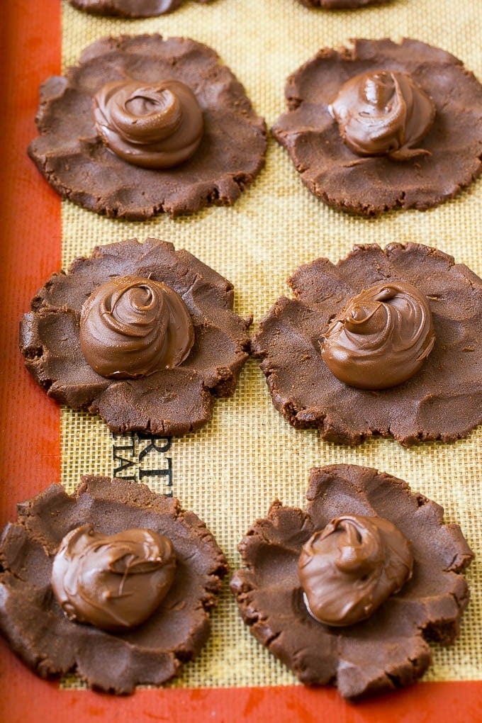 Nutella Cookies Recipe | Nutella Stuffed Cookies | Chocolate Cookies #nutella #chocolate #cookies #baking #dessert #edsug Cookie dough with dollops of nutella in the center.