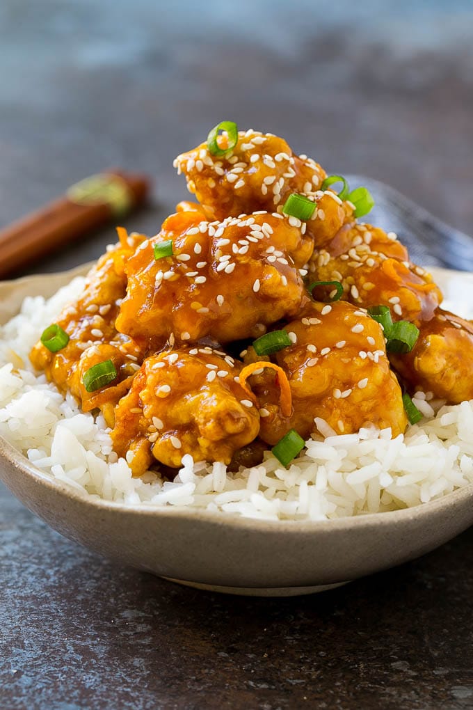 Orange Chicken Recipe | Chinese Orange Chicken | Panda Express Orange Chicken #orange #chicken #takeout #chinesefood #dinner #edsug A bowl of orange chicken served over steamed rice and topped with sesame seeds.
