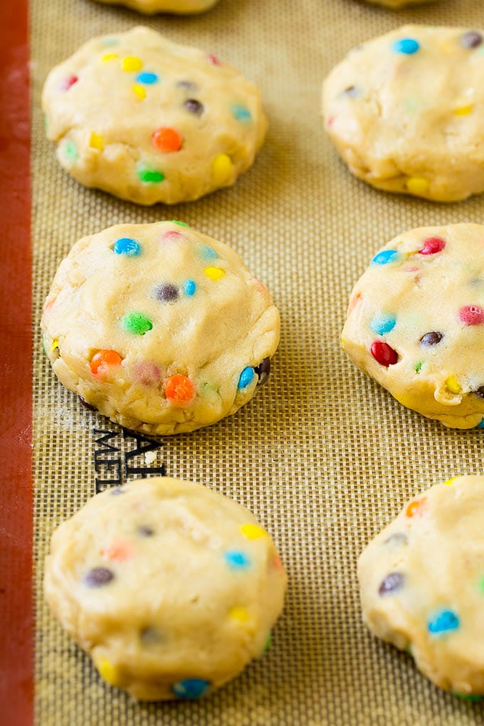 Oreo Stuffed Cookies Recipe | M&M's cookies | Stuffed Cookies #cookies #chocolate #oreos #dessert #baking #edsug Cookie dough balls stuffed with Oreo cookies on a sheet pan.