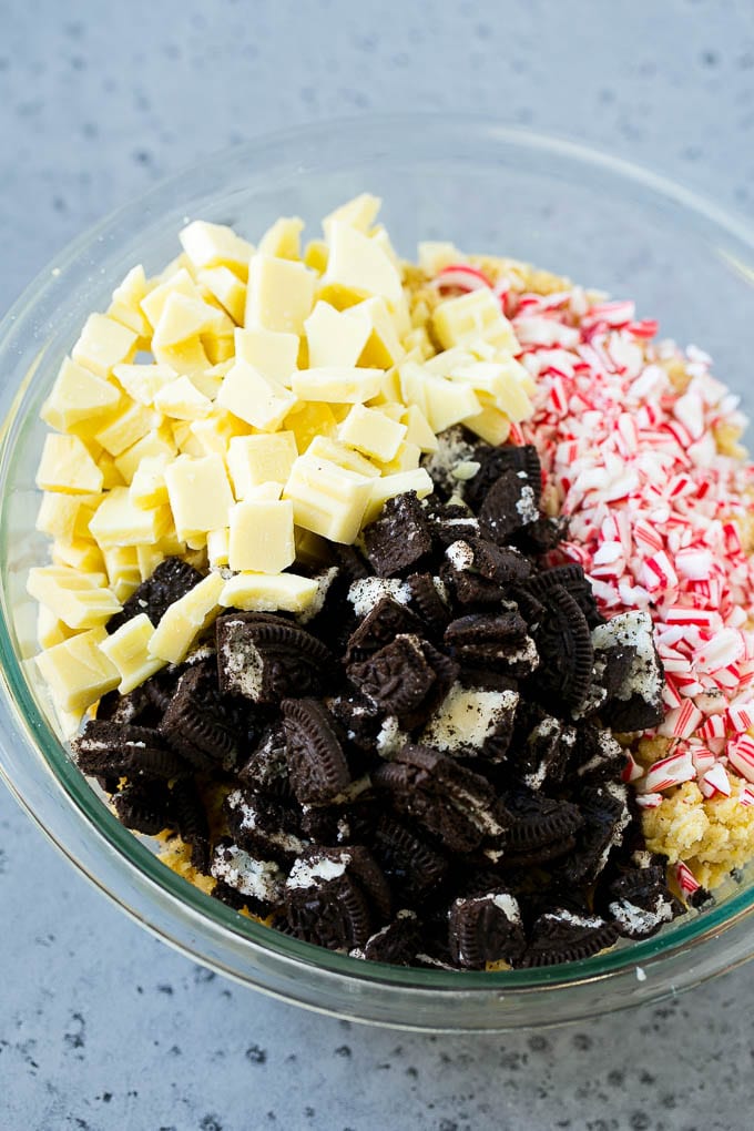 Oreo Peppermint Cookies Recipe | Candy Cane Cookies | Oreo Cookies #oreo #peppermint #cookies #baking #Christmas #sweets #edsug A bowl of dough with Oreo pieces, white chocolate chunks and crushed candy canes.