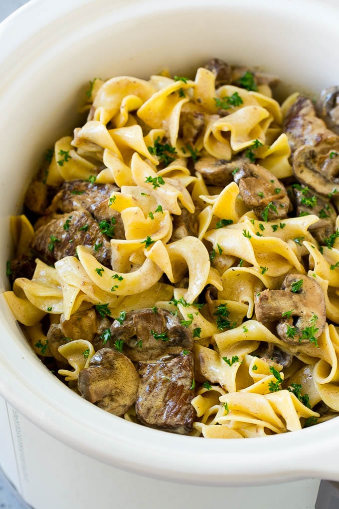 Slow Cooker Beef Stroganoff Recipe | Crock Pot Beef Stroganoff | Beef Recipe #slowcooker #crockpot #beef #mushrooms #pasta #dinner #edsug Slow cooker beef stroganoff with chunks of beef, mushrooms and egg noodles topped with parsley.