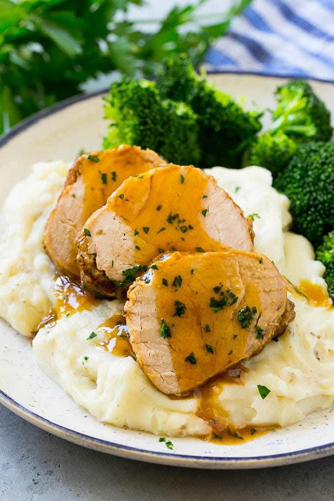 Slow Cooker Pork Tenderloin Recipe | Crock Pot Pork Tenderloin | Easy Pork Tenderloin #slowcooker #crockpot #pork #dinner #edsug Sliced slow cooker pork tenderloin served over mashed potatoes with broccoli.