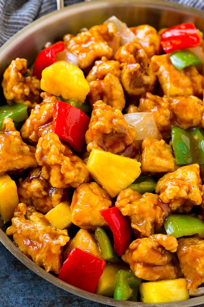 Sweet and Sour Chicken Recipe | Chinese Food Copycat Recipe | Chicken with Pineapple #chicken #chinesefood #pineapple #stirfry #takeout #dinner #edsug A frying pan of sweet and sour chicken with crispy chicken, pineapple, bell peppers and onions.