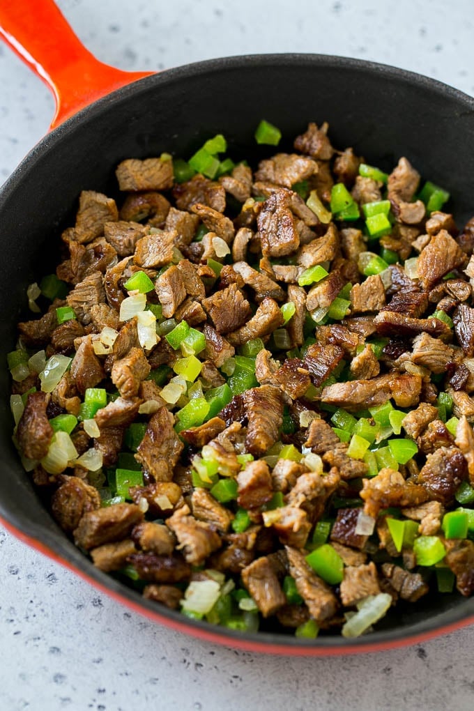 Philly Cheesesteak Dip Recipe | Cheesy Dip | Baked Cheese Dip #steak #dip #appetizer #cheese #edsug Seared rib eye steak, peppers and onions in a pan.